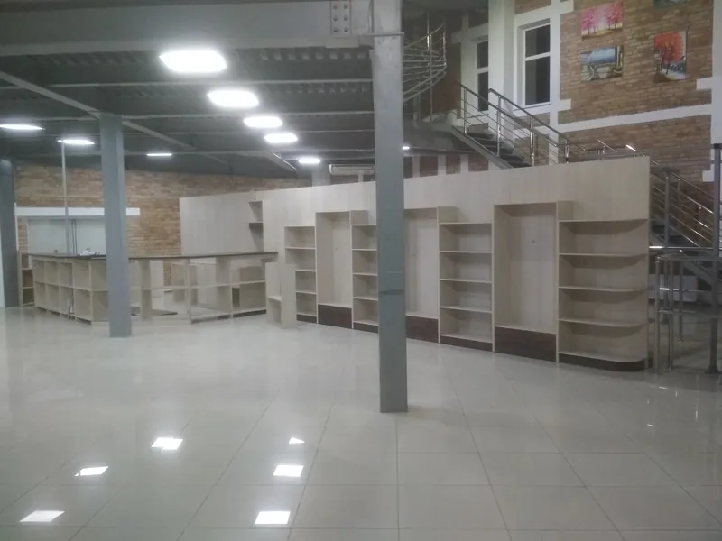 Монтаж: стеллажная стена и стойка в зале, справа лестница на антресоль, в центре стальная колонна