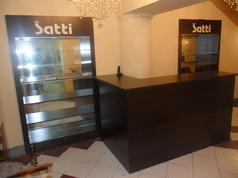 Стойка ресепшен и витрина с логотипом Satti в салоне красоты