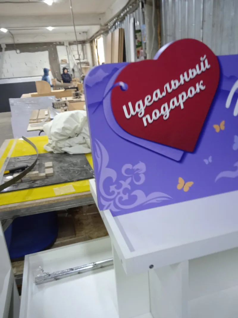 На производстве: сердце «Идеальный подарок» на фиолетовом фасаде дисплея