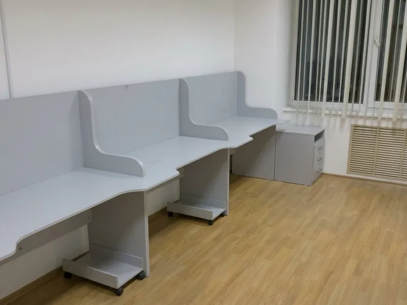 Офисные столы с высокими перегородками вдоль окна