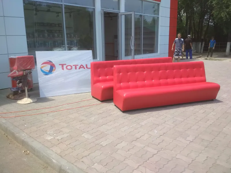 Два красных дивана со стёжкой и вывеска TOTAL перед входом