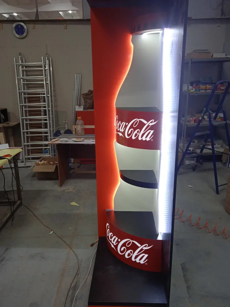 Торец с подсветкой в форме бутылки Coca-Cola на производстве