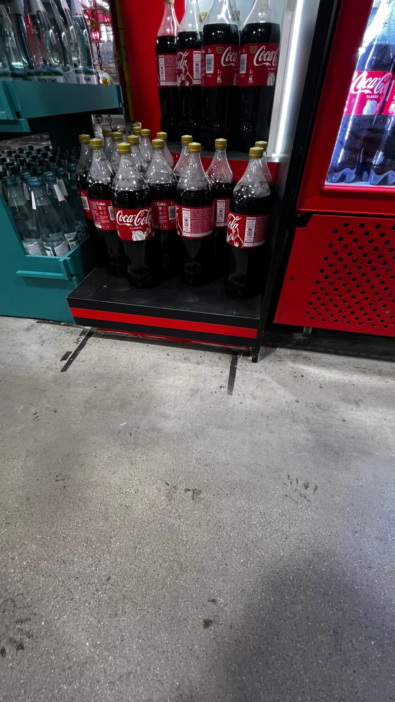 Нижняя часть торца: полка с бутылками Coca-Cola и красное основание