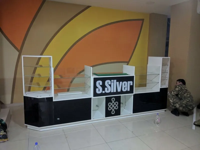 Ювелирный остров с логотипом S.Silver у стены с оранжево-жёлтыми дугами. Торговый центр