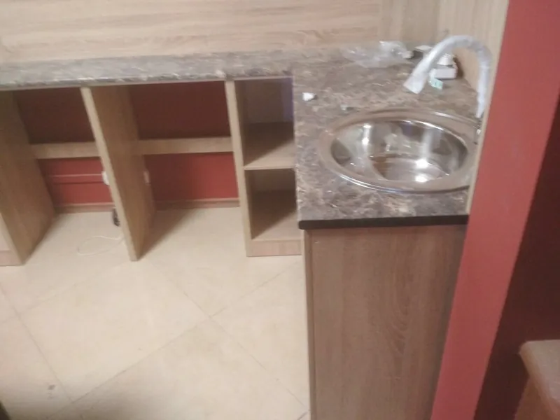 Каменная столешница с мойкой и открытые полки под ней